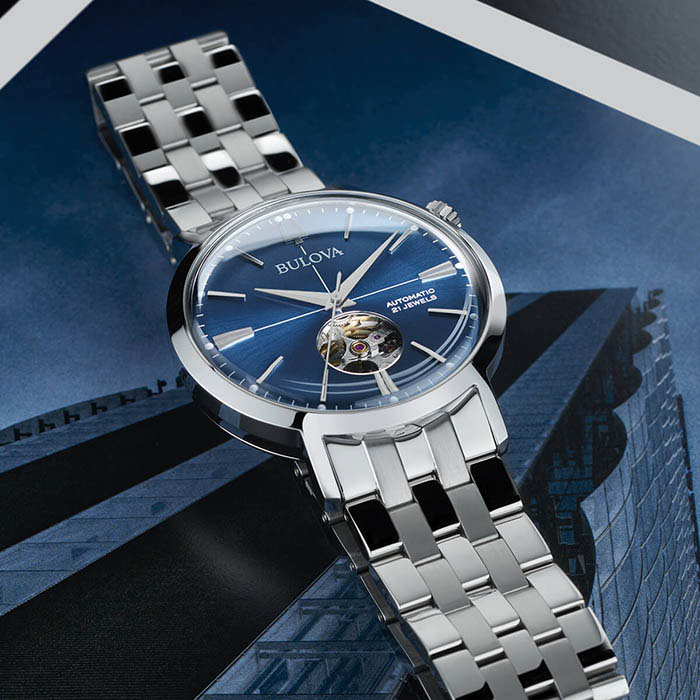 Relógio com pulseira metálica cinza e mostrador metálico azul, da coleção Aerojet de relógios Bulova, inspirados no design vintage típico dos anos 1960. 