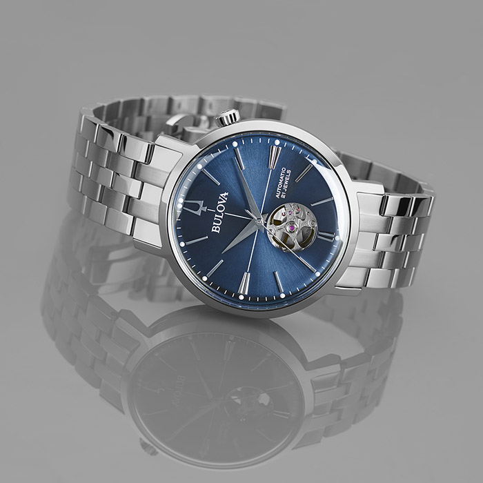 Relógio com pulseira metálica cinza e mostrador metálico azul, da coleção Aerojet de relógios Bulova, inspirados no design vintage típico dos anos 1960.