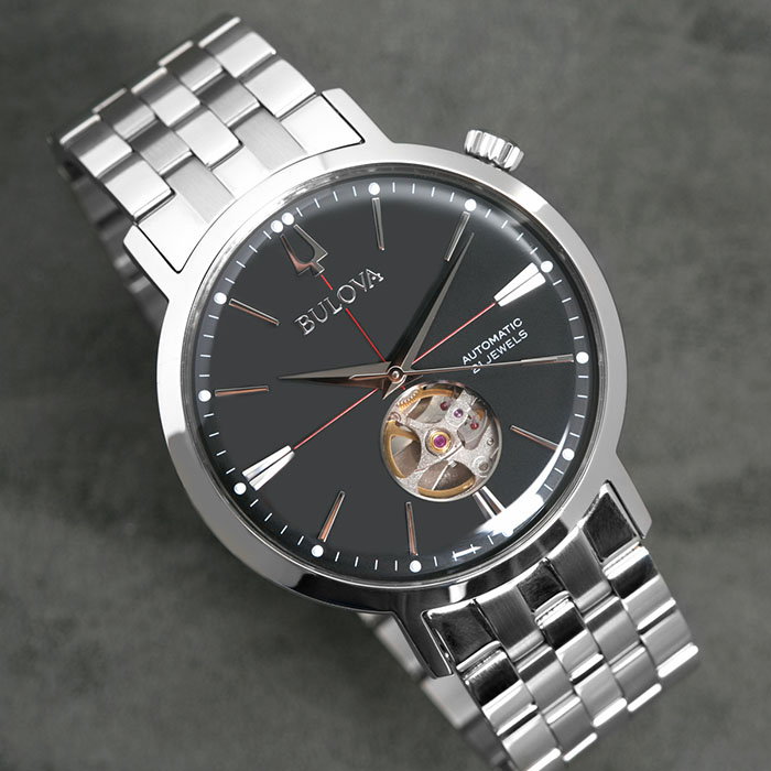 Relógio com pulseira metálica cinza e mostrador metálico negro, da coleção Aerojet de relógios Bulova, inspirada no design vintage típico dos anos 1960.