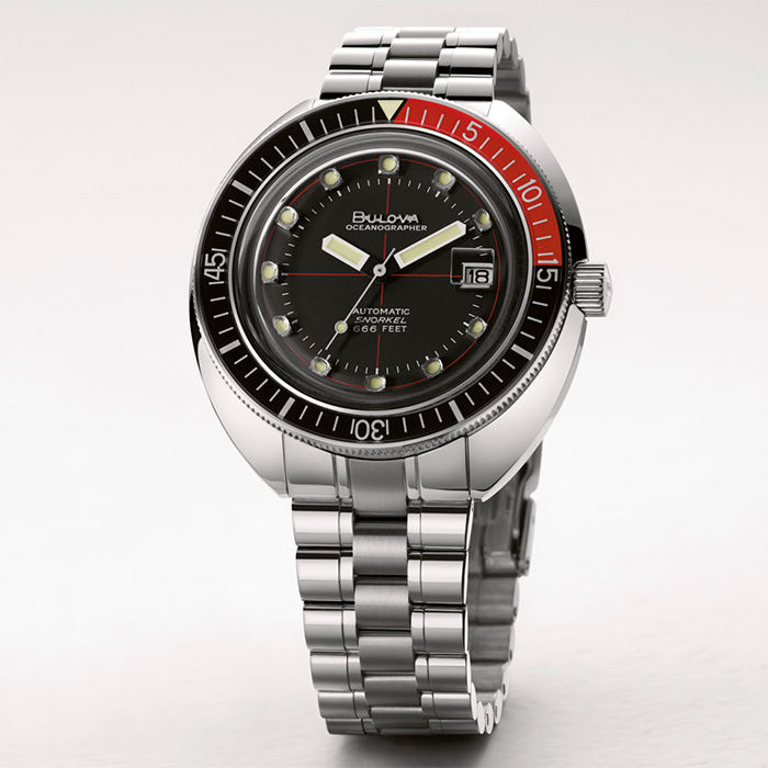 Relógio metálico com mostrador negro, com detalhes em vermelho, da coleção Oceanographer "Devil Diver" de relógios Bulova, uma homenagem ao mergulho de profundidade. Relógios resistentes à água.